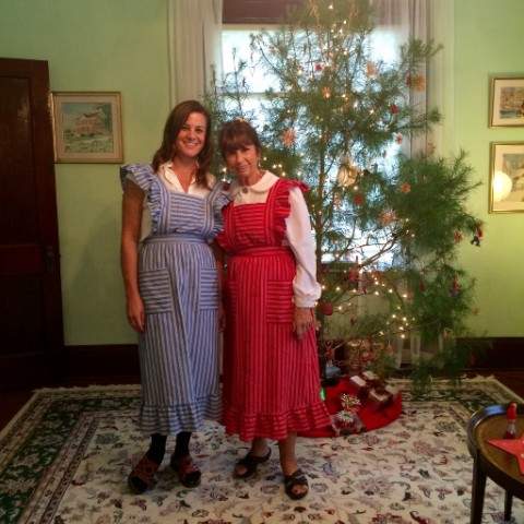 Two ladies dressed up in front of Christmas tree
